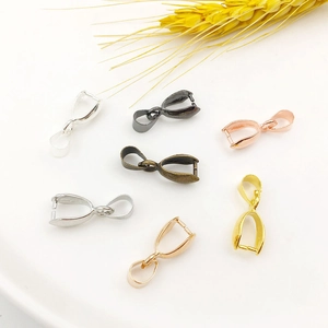 Detail view of copper jewelry pinch bails in various metallic finishes on white background