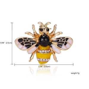 Detailed view of bee brooch with black stone, yellow enamel, and rhinestone accents