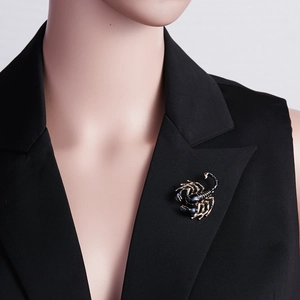 Realistic scorpion brooch in gold and black enamel pinned on a black suit lapel