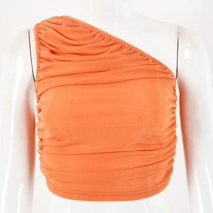 Detail of orange one-shoulder crop top showing elastic pleated texture and slim fit design