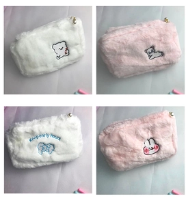 Detail of plush cosmetic bags featuring cute embroidered animal faces and pearl zippers