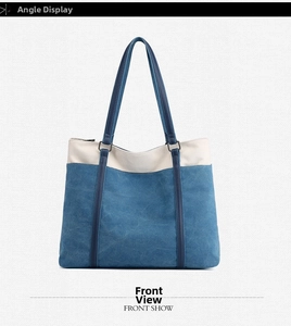 Detail of blue and beige canvas tote bag with contrast stitching and metal ring connectors