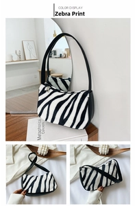 Close-up of zebra print faux fur shoulder bag featuring metal zipper and black leather straps