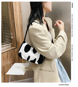 Side view of zebra print plush shoulder bag showing size and fit on model's outfit