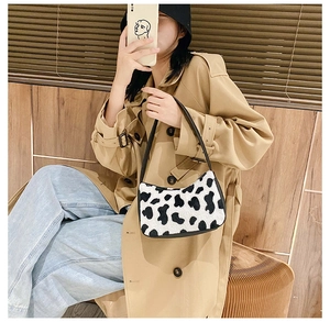 Close-up of zebra print faux fur shoulder bag with slender strap shown in mirror selfie