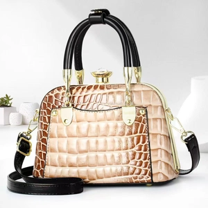 Detail of beige and brown crocodile texture bag with gold crystal lock and hardware