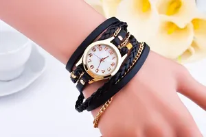 Detail of vintage wrap watch with gold case and multilayered black leather cord straps