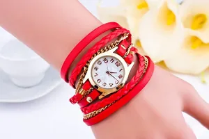 Detail of red multilayer woven rope and gold chain wrist watch on a female model