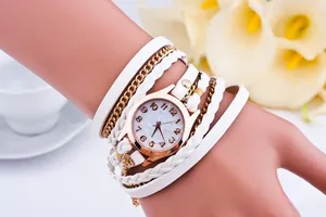 Close-up of white multi-layer wrap watch with leather straps and rose gold dial