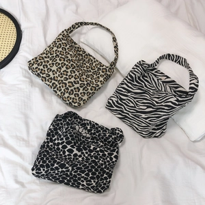 Minimalist animal print canvas tote bags in leopard and zebra patterns on white fabric
