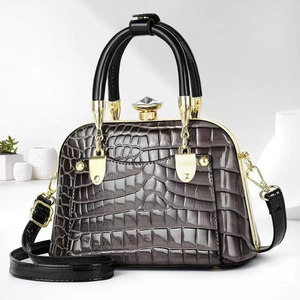 Detail of grey crocodile embossed handbag with luxury gold hardware and crystal clasp