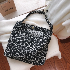 Detail shot of black and white leopard print tote with metal magnetic clasp and inner lining