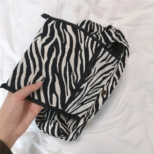 Detail view of durable canvas fabric and magnetic metal snap on zebra pattern tote bag