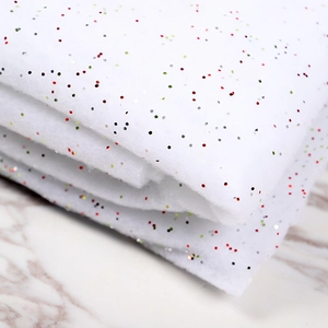 Artificial white Christmas snow blanket with colorful glitter for festive winter scene decoration