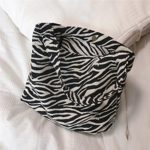 Macro detail of zebra print canvas bag with magnetic metal clasp and interior lining