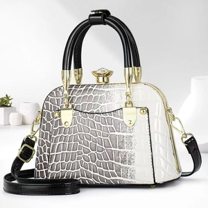Detailed shot of leather handbag with faux crocodile texture and gold crown lock