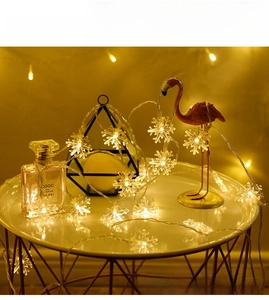 Macro shot of warm yellow LED snowflake fairy lights for cozy home decoration