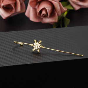 Elegant snowflake ear cuff with gold plating and zircons on a textured black base