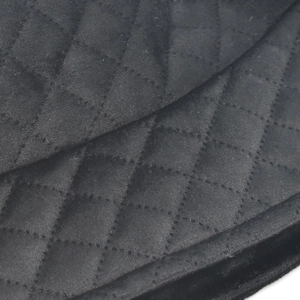 Detail of black quilted fabric with classic diamond stitching and velvet texture for hats