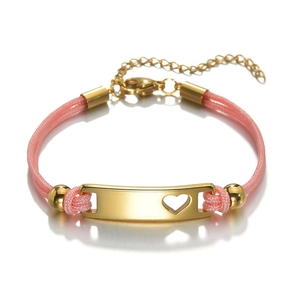 Detail of pink braided rope bracelet featuring a polished gold plate with heart cutout