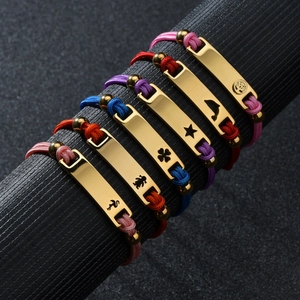 Close-up of colorful woven rope bracelets with engraved golden 18K titanium steel charms