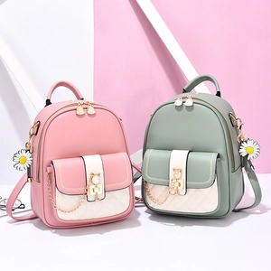 Women's mini PU leather backpacks in pink and green with quilted white flaps and daisy charm