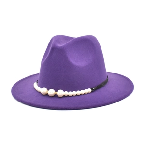 Detail of purple felt jazz hat featuring black band with pearl and gold accents