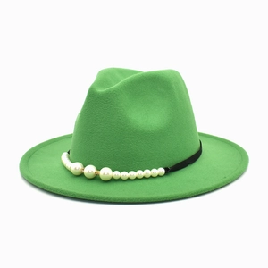 Detail of sage green wool fedora hat featuring an elegant pearl-embellished black band