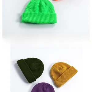 Close-up of multicolored knitted beanies showing fine texture and ribbed fold-over cuff