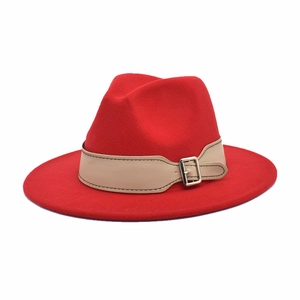 Detail of red wool fedora hat featuring a khaki leather strap and silver metal buckle