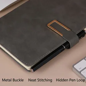 Gray A5 leather notebook with golden magnetic buckle and pen holder on office desk