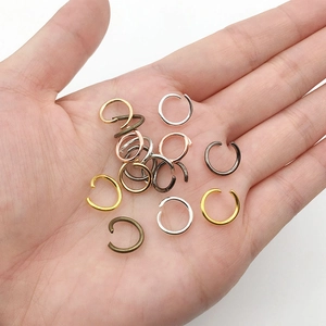 Close-up of assorted color open jump rings for jewelry making held in palm