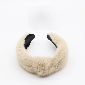 Detailed close-up of beige plush headband with knot design and soft texture finish