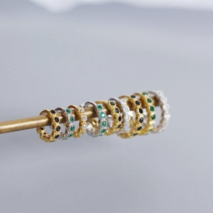 Macro shot of S925 sterling silver hoop earrings with emerald and black zircon stones