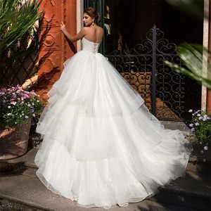 Elegant off-shoulder white ball gown wedding dress with lace bodice and tiered tulle train