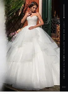 Detailed view of white off-shoulder wedding dress with intricate floral lace and tulle skirt