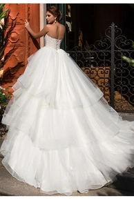 Detailed back view of off-shoulder lace wedding gown with corset tie and layered tulle train