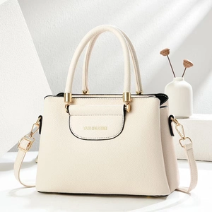 Chic beige lychee texture handbag with gold hardware and adjustable strap in minimalist setting
