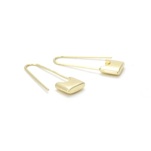 Macro detail of minimalist gold-plated safety pin earrings with a polished metallic finish