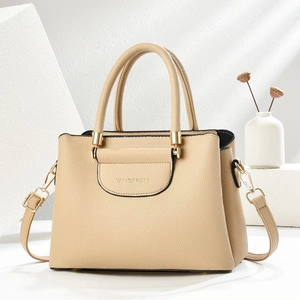 Chic beige lychee textured handbag with gold hardware on minimalist stone display