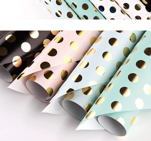 Polka dot gold foil gift wrapping paper rolls in various colors for festive celebrations