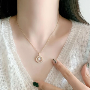 Detailed close-up of a luxury gold-plated necklace with a sparkling round zircon pendant