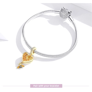 Detail of S925 sterling silver snake chain bracelet with golden honeycomb heart charm