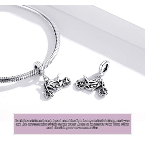 Detailed view of two 925 sterling silver motorcycle pendants on a snake chain bracelet