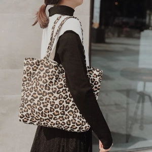 Outdoor shot of a stylish leopard print canvas tote bag carried by a model on her shoulder