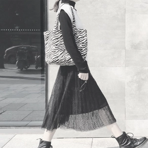 Fashionable zebra print canvas tote bag shown with a street style outfit in a city setting