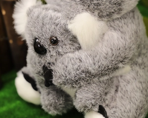 Dettaglio ravvicinato del morbido peluche a forma di koala grigio e bianco con texture soffice