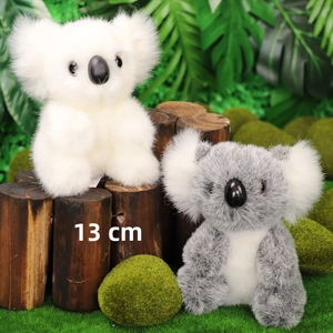 Dettaglio di peluche koala da 13cm grigio e bianco in un ambiente di foresta naturale