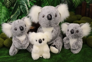 Dettaglio di peluche a forma di koala in varie dimensioni su sfondo di muschio naturale