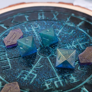 Macro detail of glitter resin rune dice and flat rune stones on a celestial disc mold